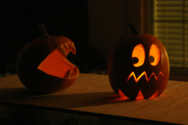 Pac-Man and Ghost pumpkins at night with candles